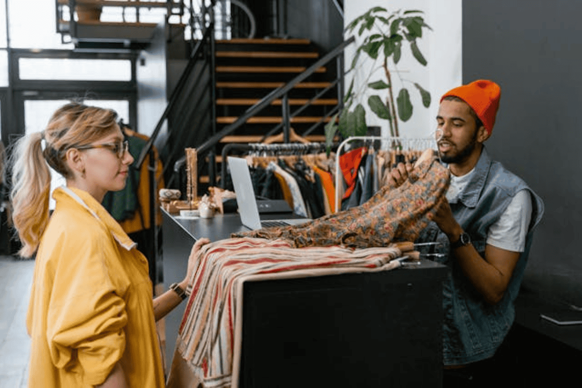 A woman in a yellow shirt buying clothes