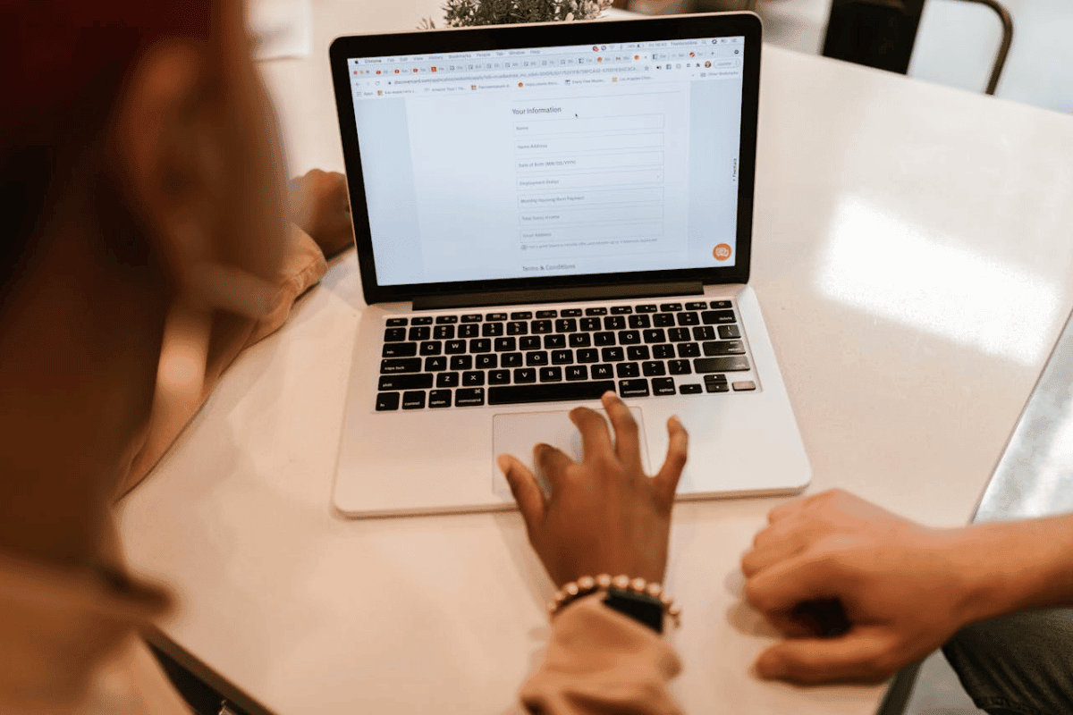 A person filling out a form using a laptop