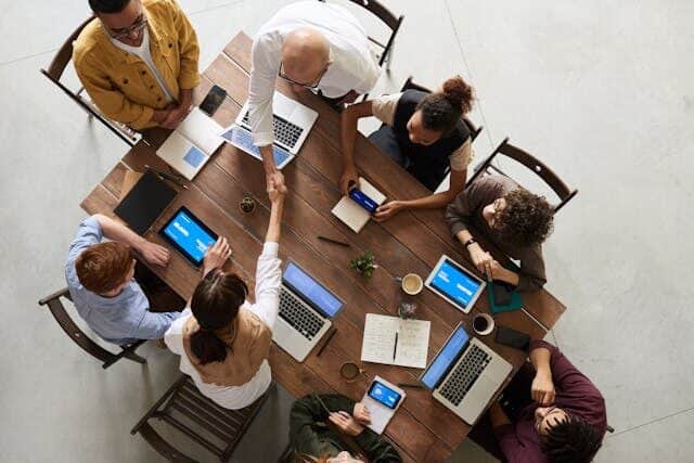 People sitting by the table with their digital devices