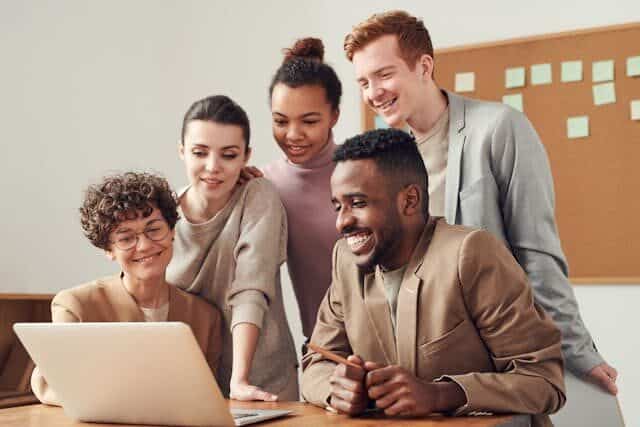 A group of colleagues looking at a laptop screen
