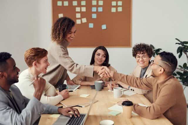 Two people shaking hands during a meeting